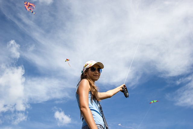 Sunny weather with girl flying kites